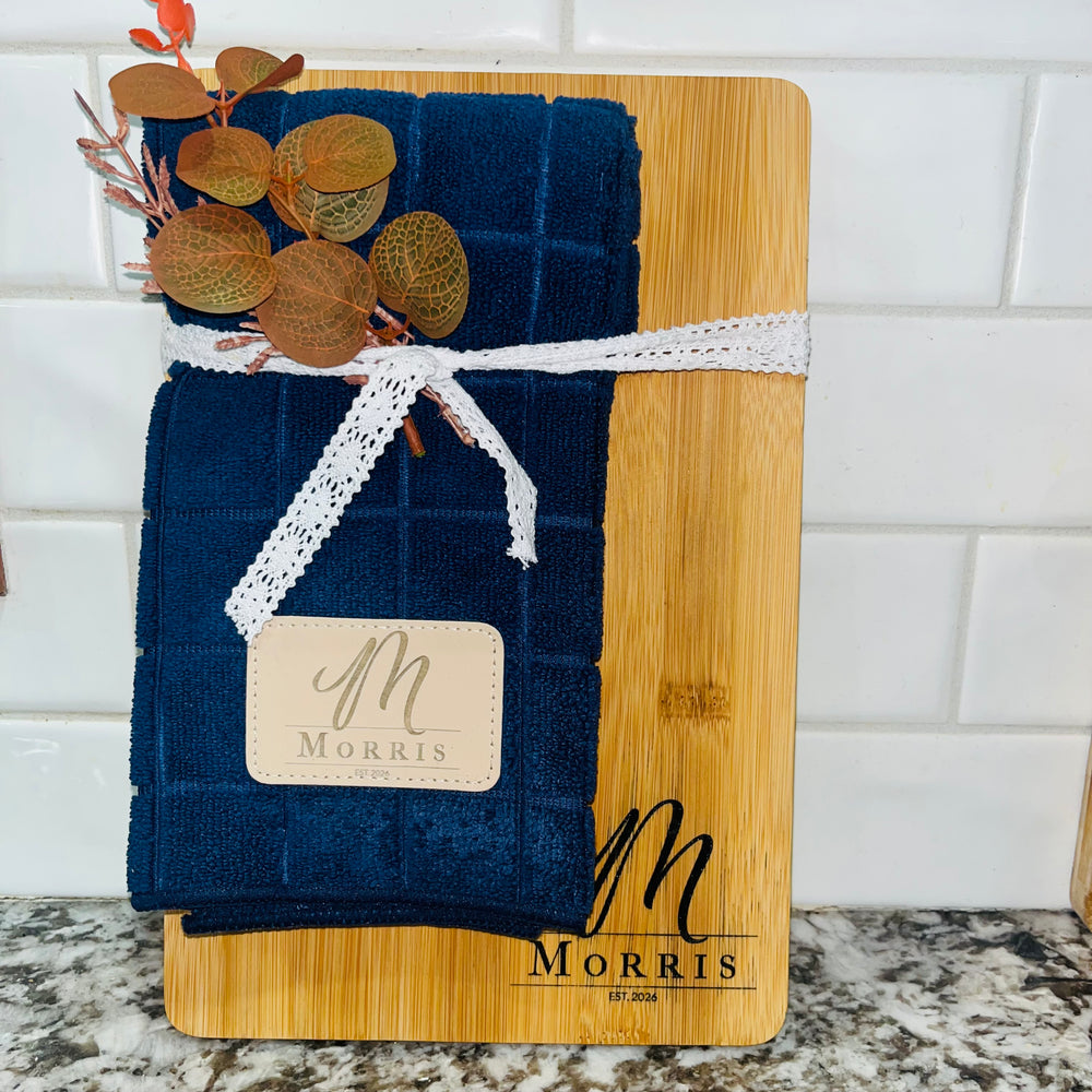 The perfect gift, ready to give! This engraved cutting board with a matching dish towel — a beautiful, personal gift for any kitchen.The board is custom engraved with a family name, monogram, and established year, and the dish towel is finished with a matching engraved leather patch, so the whole set looks made for each other. It arrives beautifully bundled and ready to give — perfect for weddings, housewarmings, holidays, and just because.
